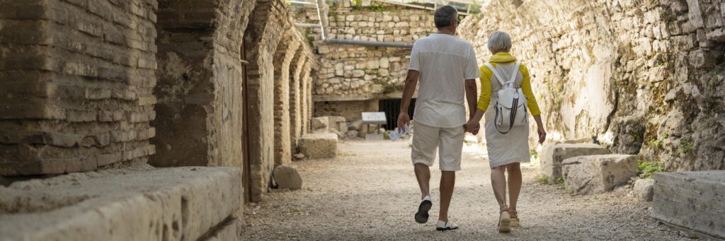 Casal sênior caminhando de mãos dadas durante viagem à Grécia