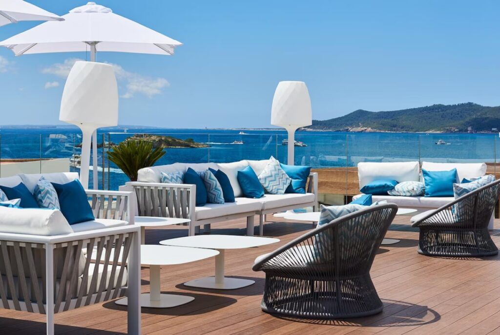Terraço do Eurostars Ibiza com vista para o mar Mediterrâneo e áreas de descanso ao ar livre.