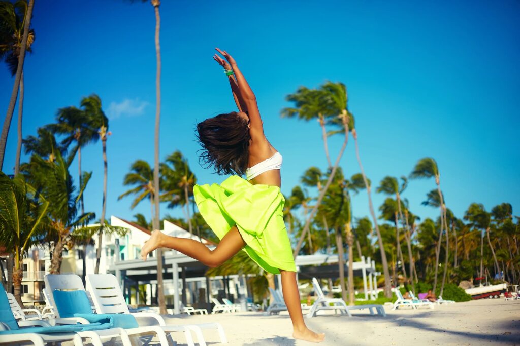 Mulher sorridente na praia de Cancún sob o céu azul, símbolo do turismo no México.
