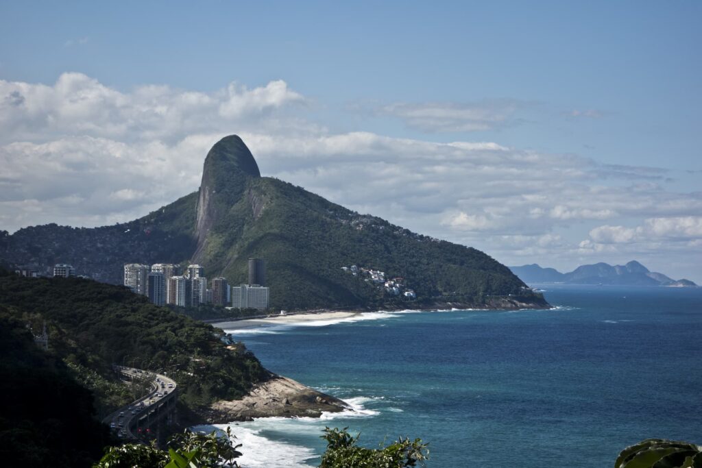 Vista aérea da praia do Rio de Janeiro com montanhas ao fundo.
