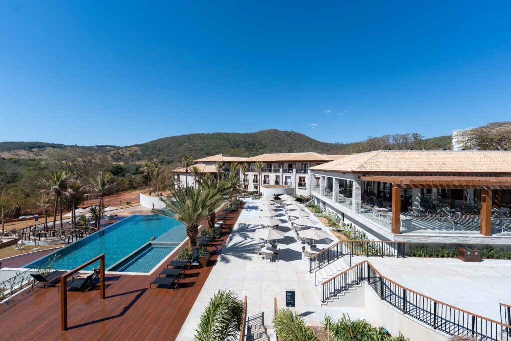 Área externa do Pyreneus Residence GAV Resorts com piscina e vista para as montanhas.