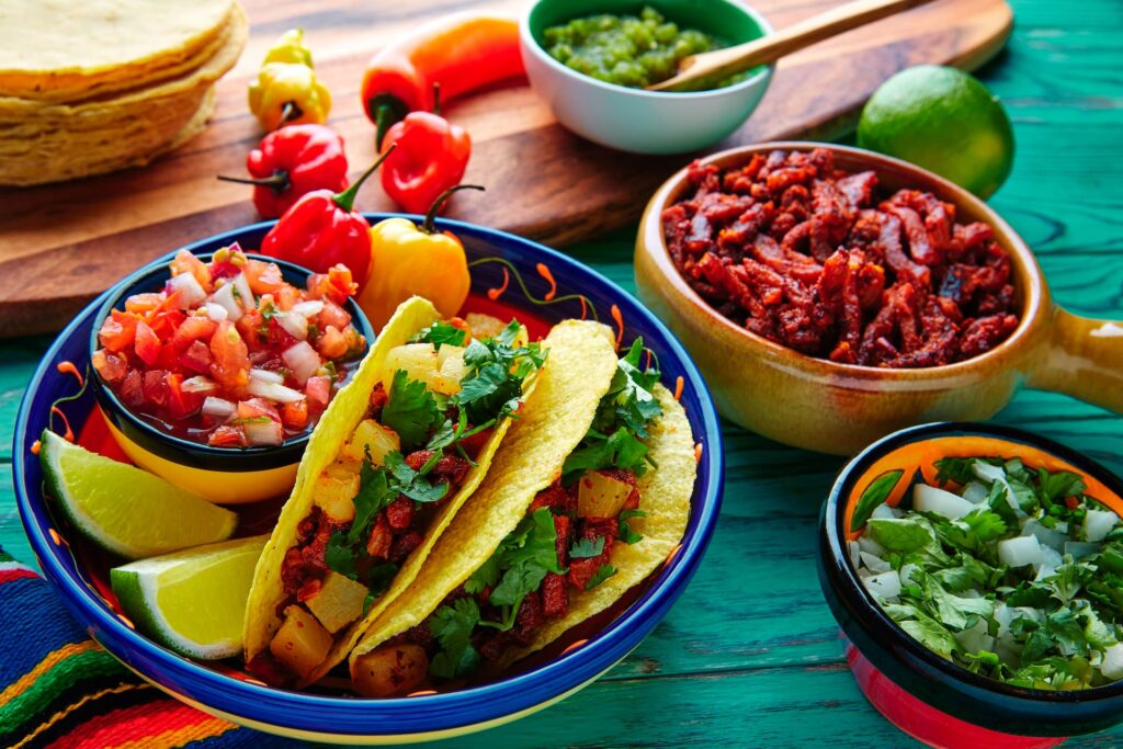 Tacos tradicionais mexicanos com abacaxi e coentro em mesa de restaurante na Cidade do México.