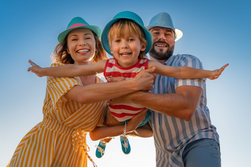 Família se divertindo ao ar livre durante férias de verão, mostrando alegria e união em uma viagem em família com crianças.