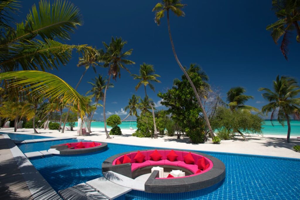 Piscina de frente para o mar no Kandima Maldives com área de convivência tropical