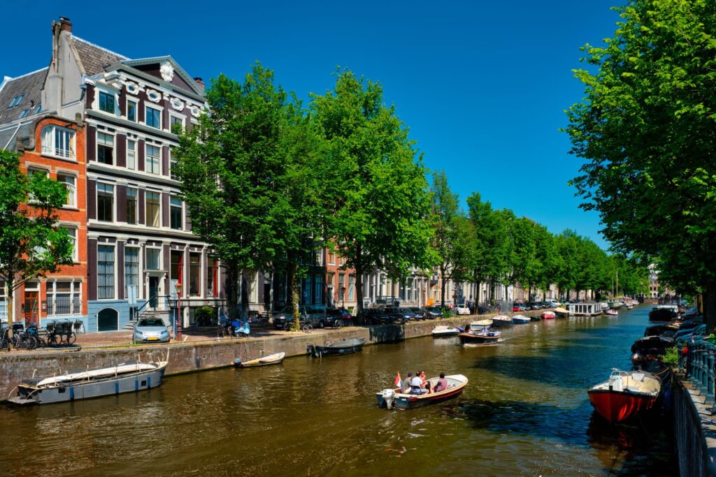 Canal de Amsterdã com barcos e casas históricas