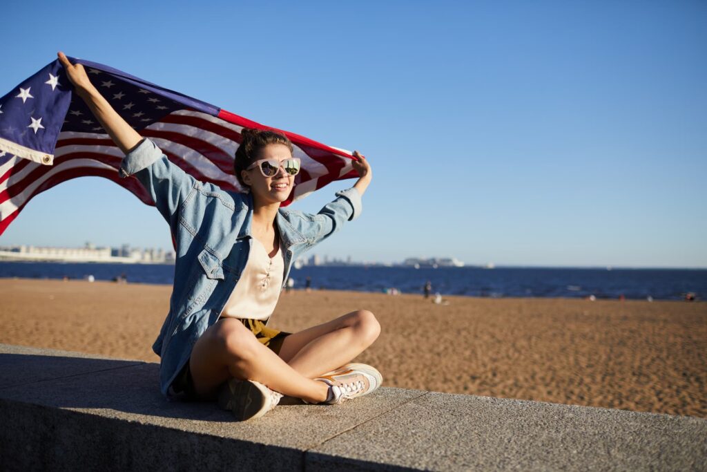 Mulher segurando a bandeira dos Estados Unidos simbolizando viagem no verão
