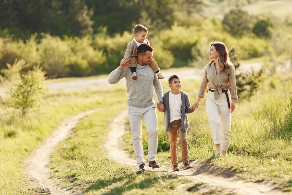 Uma família sorridente brincando alegremente em um campo aberto durante um dia ensolarado de verão. Feriados Roteiros Curtos