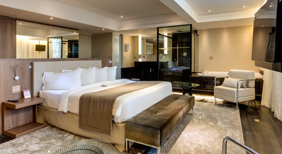 Suíte executiva ampla com cama de casal e banheira no hotel Mercure BH Lourdes