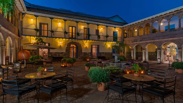 Pátio histórico e luxuoso do hotel Palácio Del Inka em Cusco, com arquitetura colonial e sofisticação.